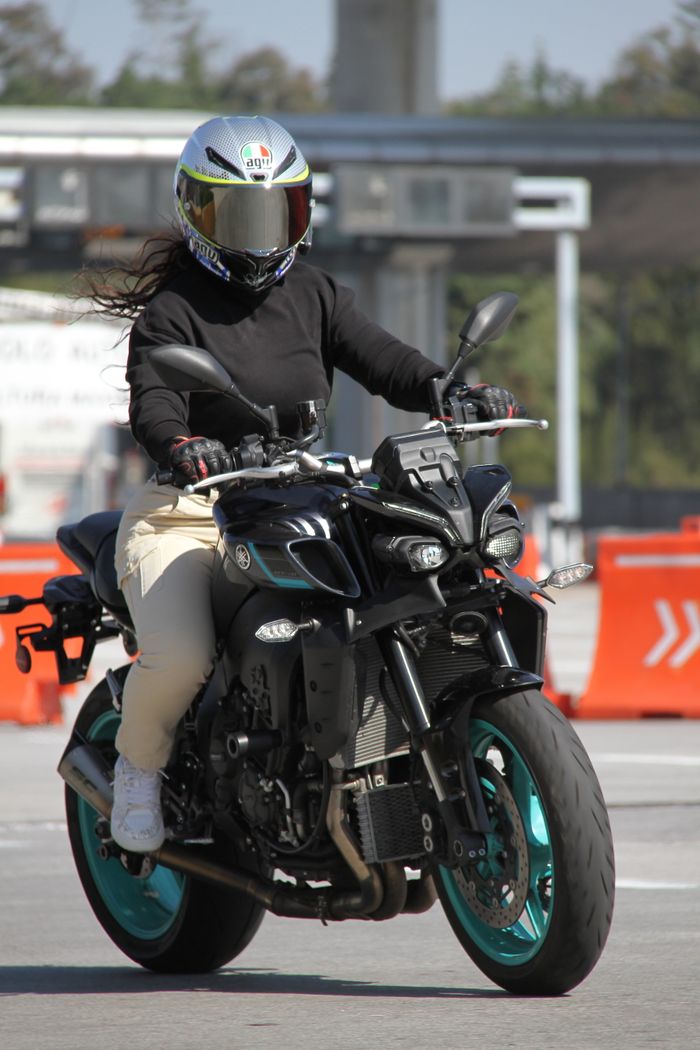 A motorcyclist riding in a controlled track environment, wearing safety gear.